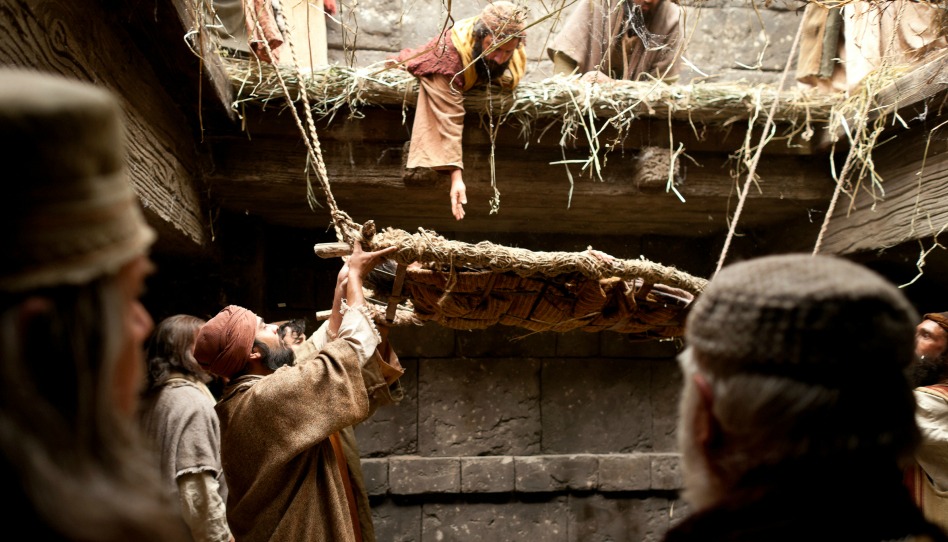 un homme paralysé est descendu sur un brancard par le toit, près de Jésus